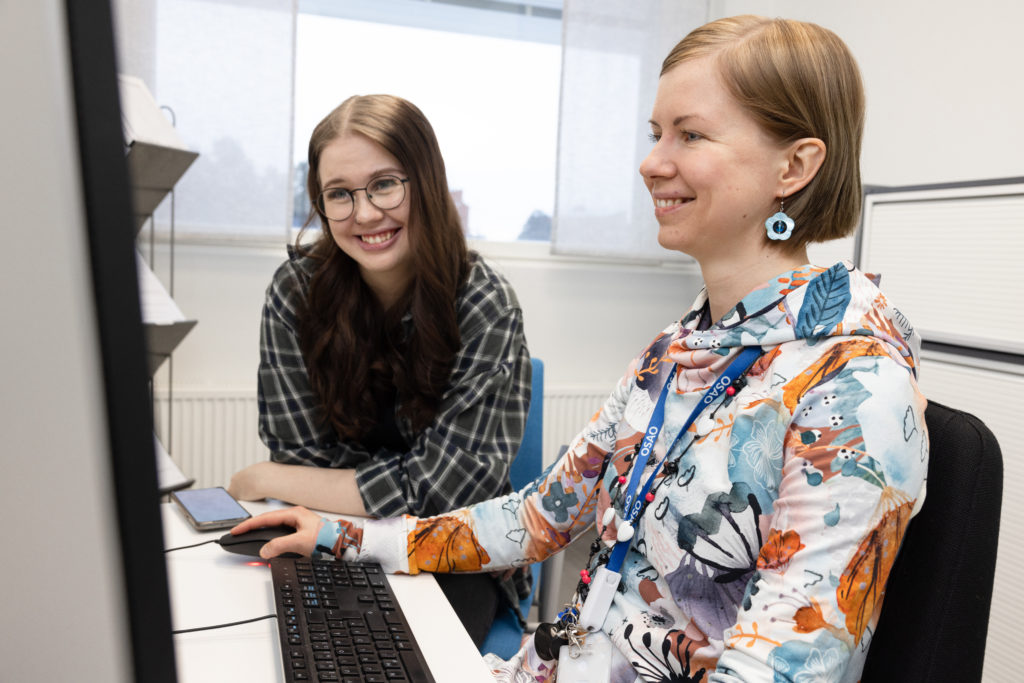 Opiskelija Oona ja opinto-ohjaaja Maria katsovat yhdessä opiskelujuttuja tietokoneelta.