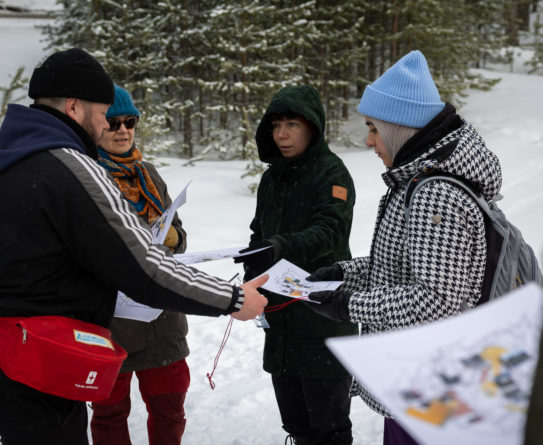 OSAOn liikuntaohjaaja opastaa Oulun kaupungin työntekijöitä kartan ja kompassin käytössä.