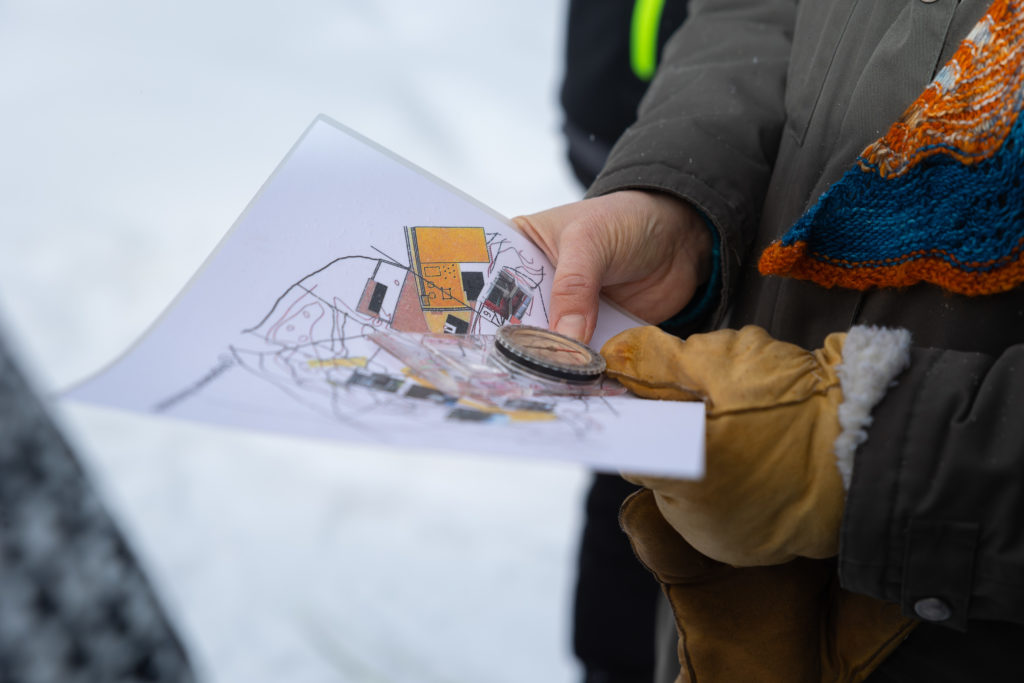 Kuvassa ihmisen kädet, jotka pitelevät karttaa ja kompassia.