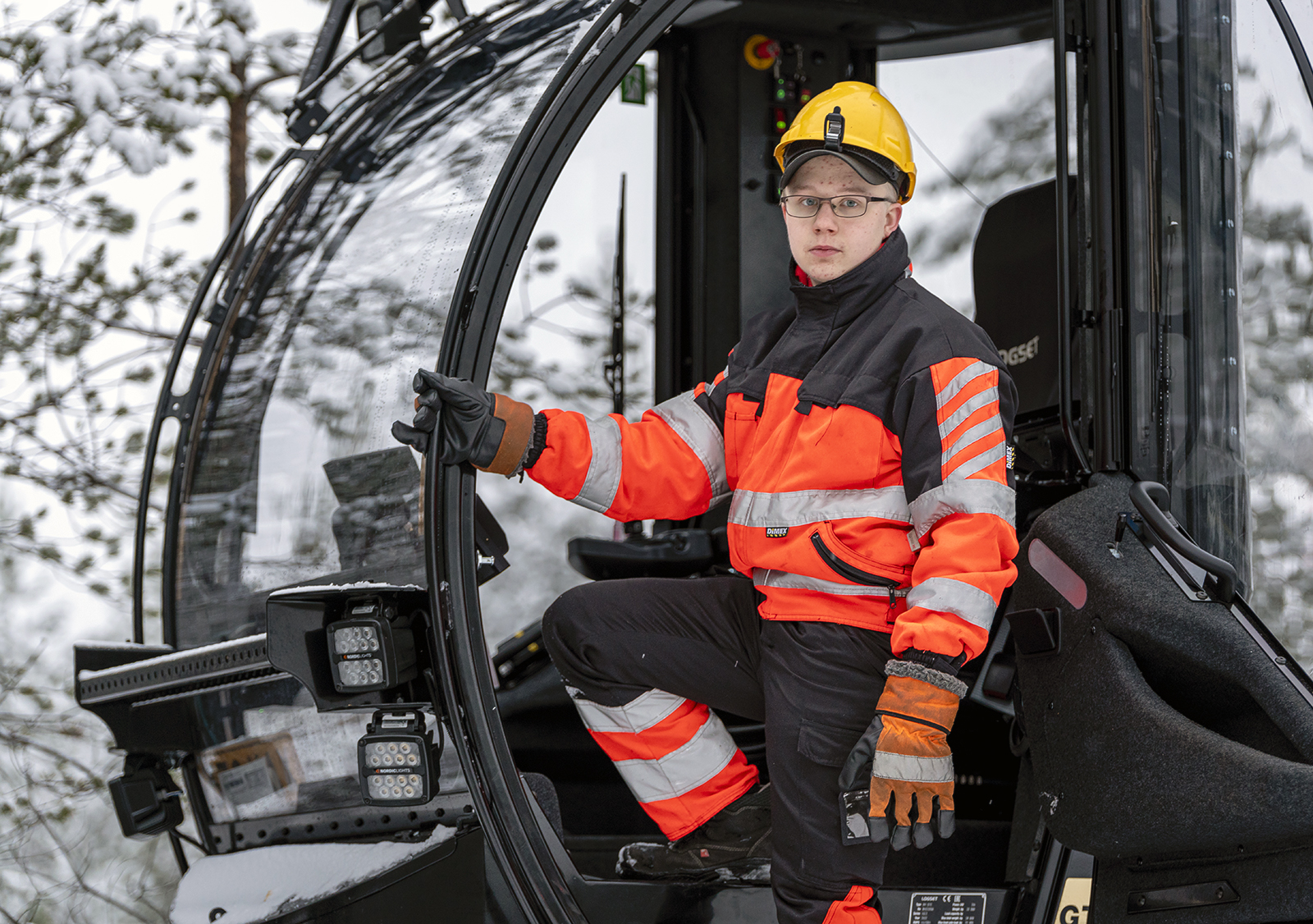 Metsäalaa opiskeleva Miikka Kuisma kuvattuna metsätyökoneen ohjaamossa.