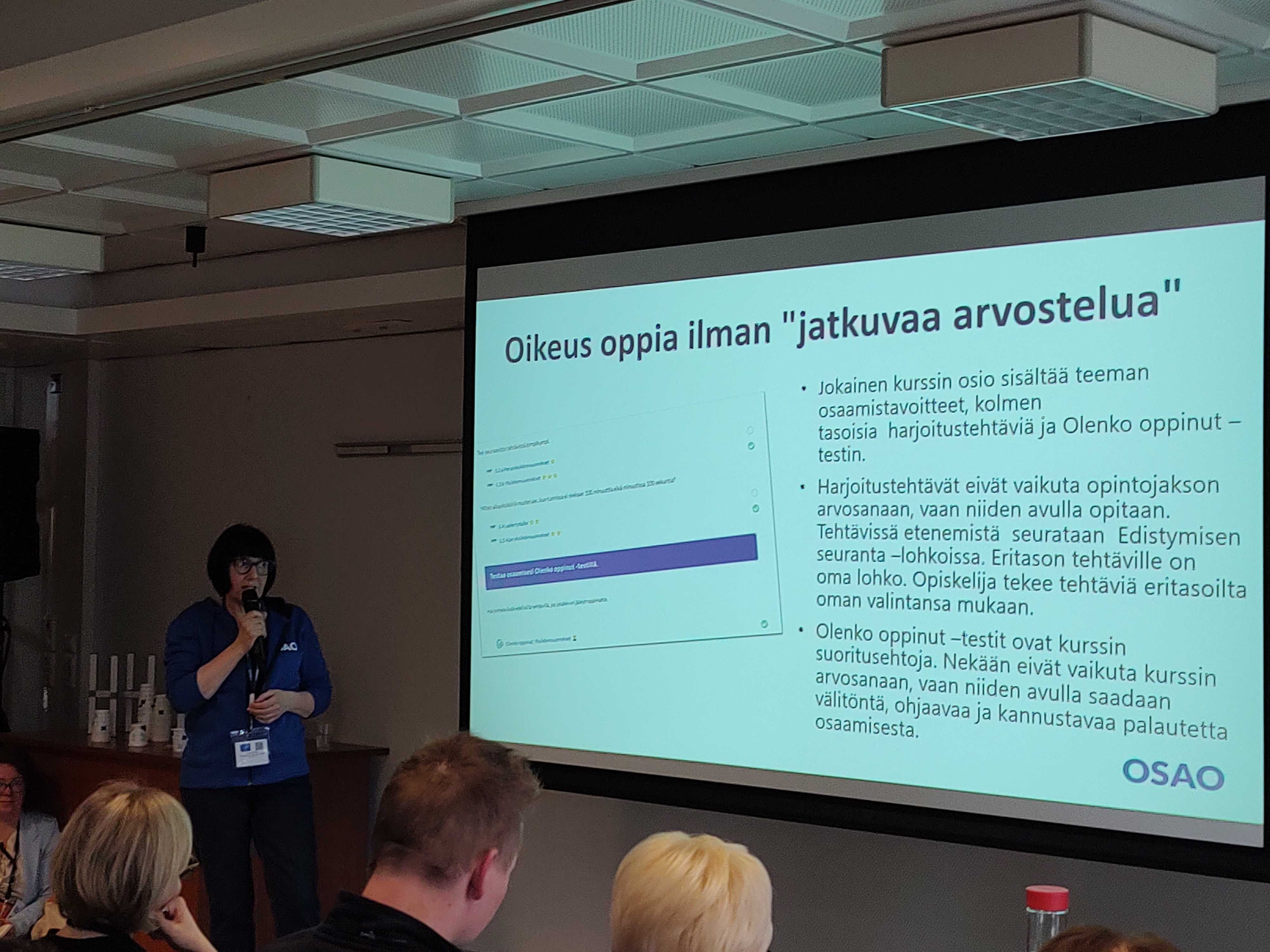 Jaana Parkkila pitämässä esittelyä oppimisanalytiikan käyttämisestä opetuksessa. Esityksessä lukee "oikeus oppia ilman jatkuvaa arvostelua".