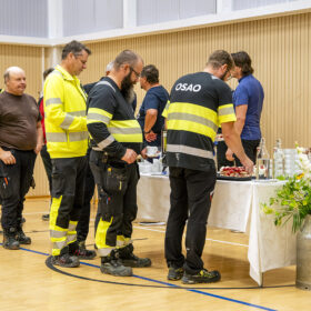 Ihmiset ottavat kakkua ja kahvia. Työasuissa lukee OSAO.