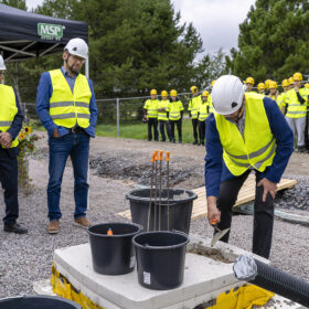 Mies asettelee laastia kivijaökaan. Muut seuraavat tilannetta.