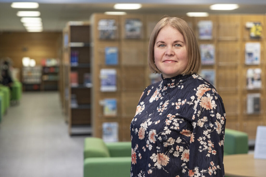 Toimialajohtaja Sari Veijola seisoo kirjaston edustalla.