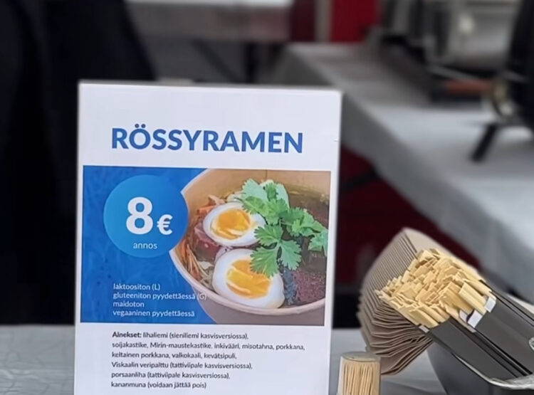 Pöydällä olevassa kyltissä mainostetaan rössyramen-ruoka-annosta.