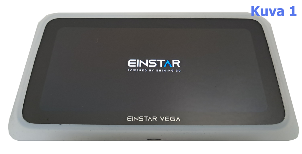 EINSTAR Vega -laite, jossa on musta näyttö ja valkoinen kehys. Näytöllä on teksti: 'EINSTAR POWERED BY SHINING 3D'. Kuvan oikeassa yläkulmassa on teksti 'Kuva 1' sinisellä.