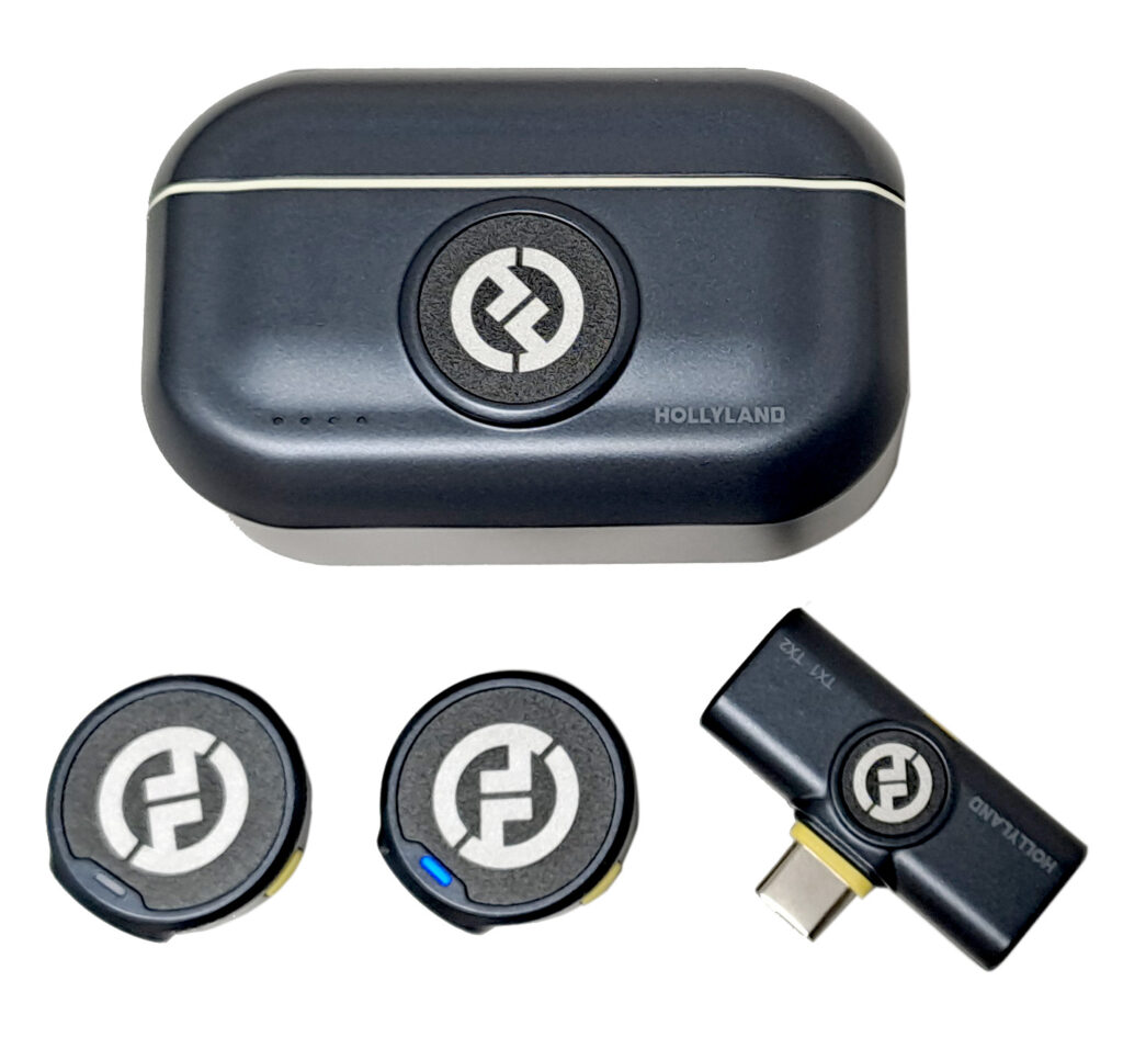 Kuvassa on Hollylandin langaton mikrofonijärjestelmä. Ylhäällä on latauskotelo ja sen alla kaksi pyöreää mikrofonia sekä vastaanotin USB-C-liitännällä.