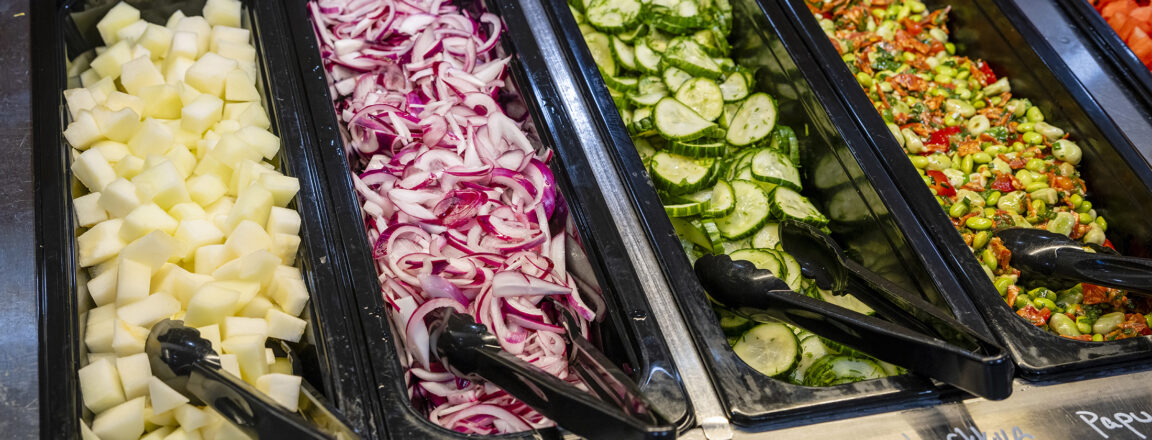 Salaattibuffetti, jossa jokaisessa astiassa on ottimet tarjoilua varten.